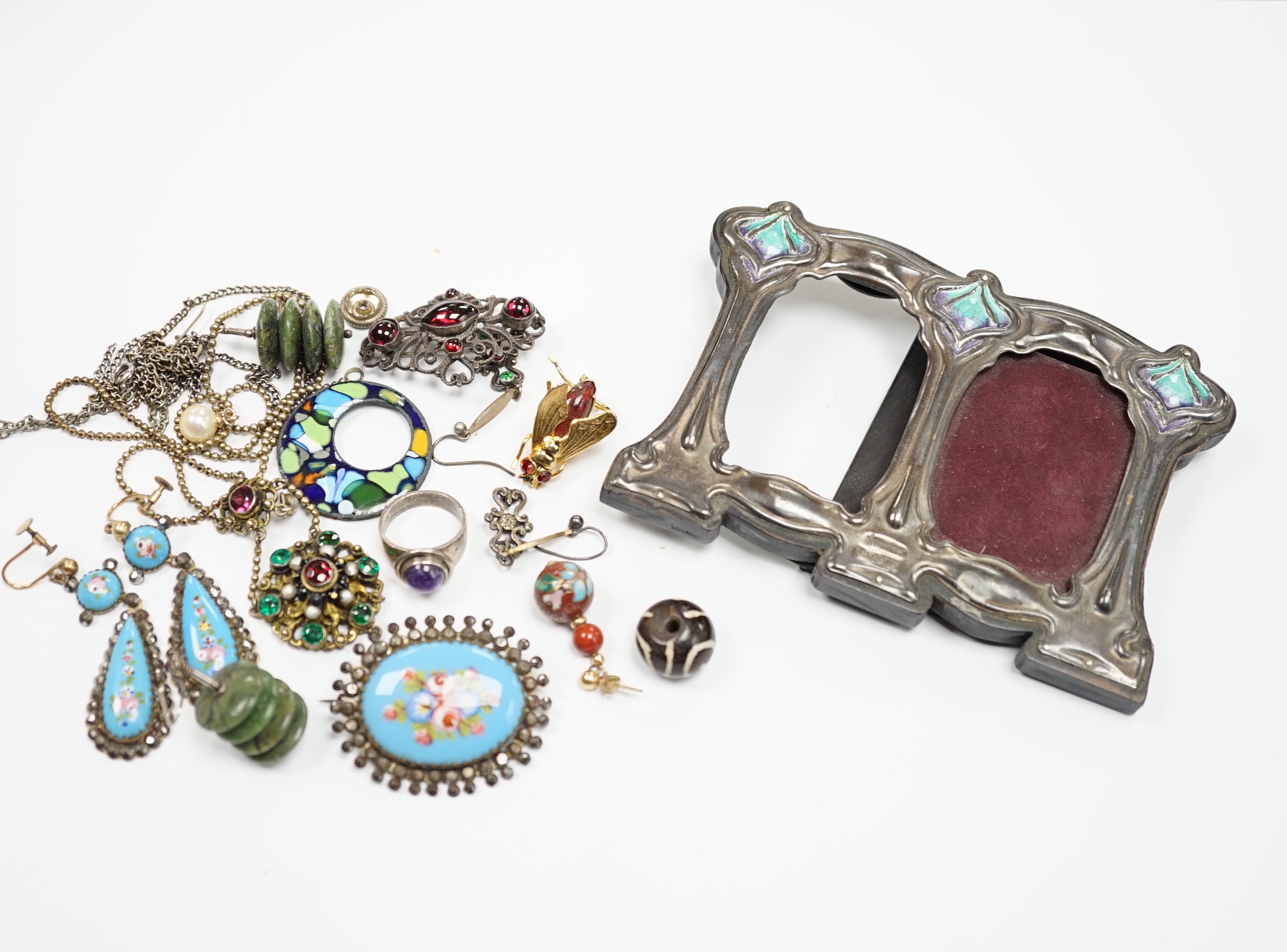 An Art Nouveau style sterling and enamelled double photograph frame, width 11.3cm, together with sundry jewellery including an Austro-Hungarian style necklace, white metal and cabochon amethyst set ring(stamped silver) e